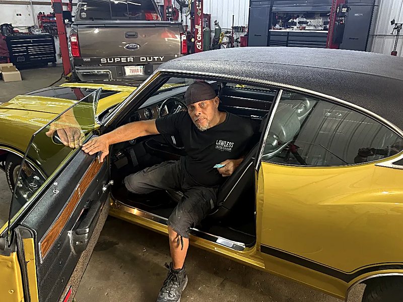 Finished gold Oldsmobile Cutlass with a black vinyl top inside the Lawless shop